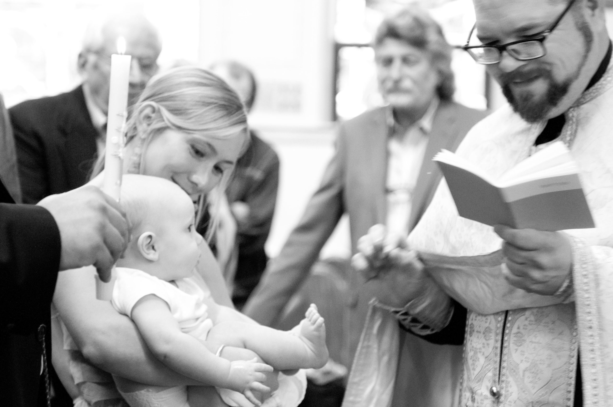 Mother holding baby during baptism at St Mary's Orthodox Cathedral in Northeast Minneapolis