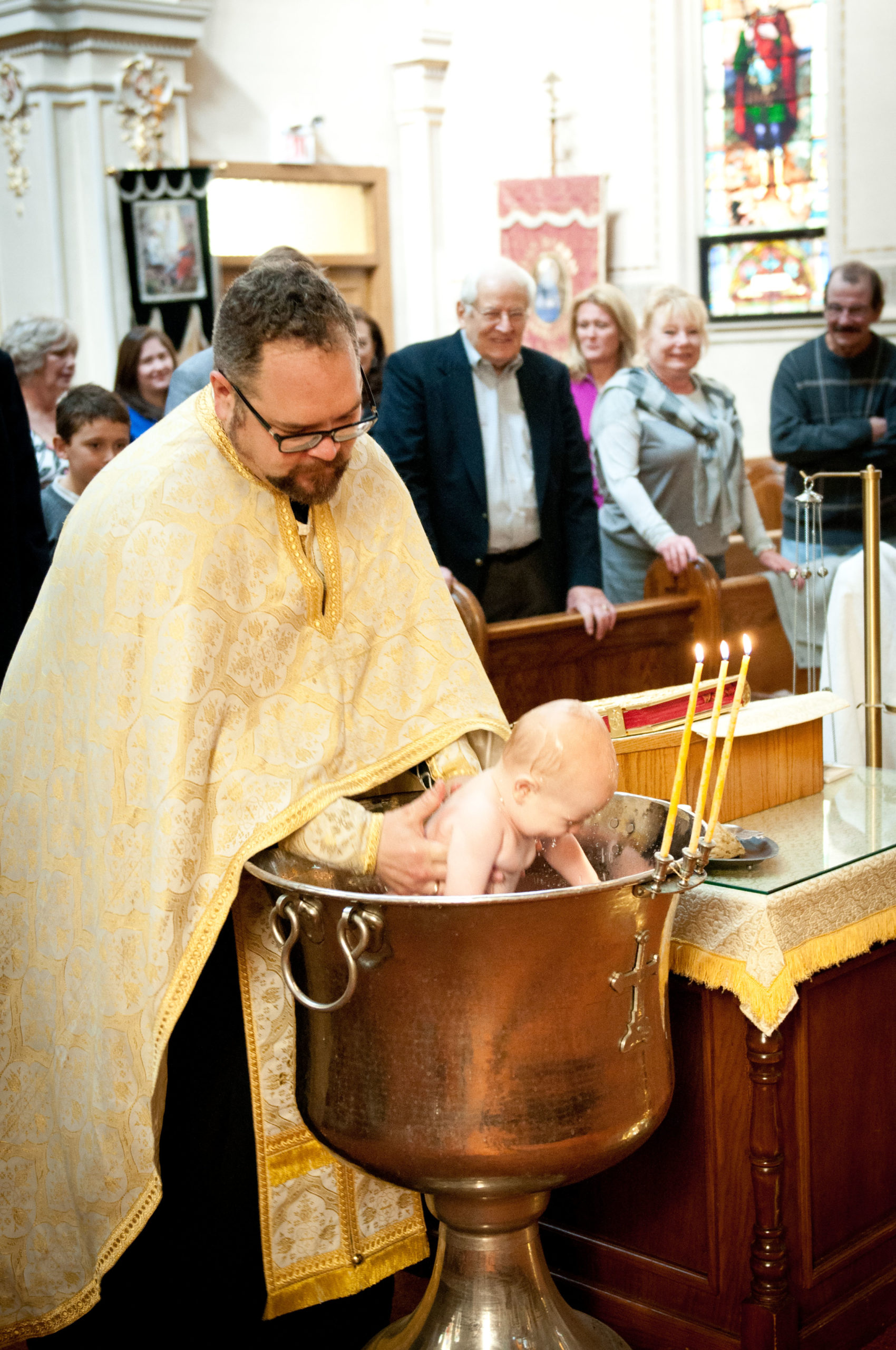 Priest baptizing baby at Saint Mary's Orthodox Cathedral in Northeast Minneapolis