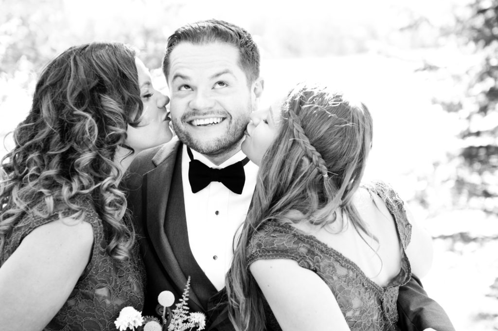 Sisters kissing groom at Minnesota wedding
