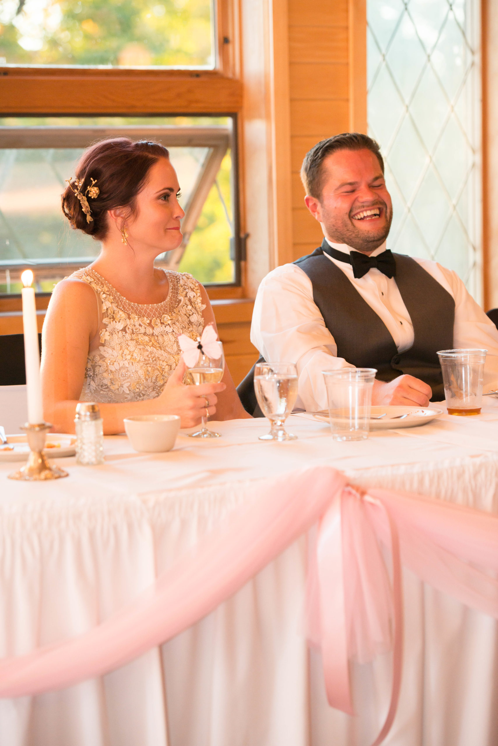 Bride and groom laughing at wedding table