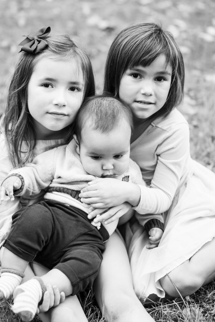 Sisters holding little brother in Minnesota