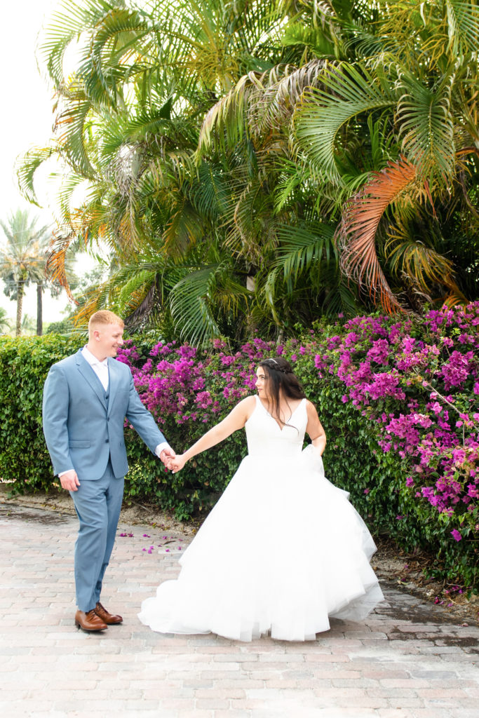 Bride and groom walking near flowers