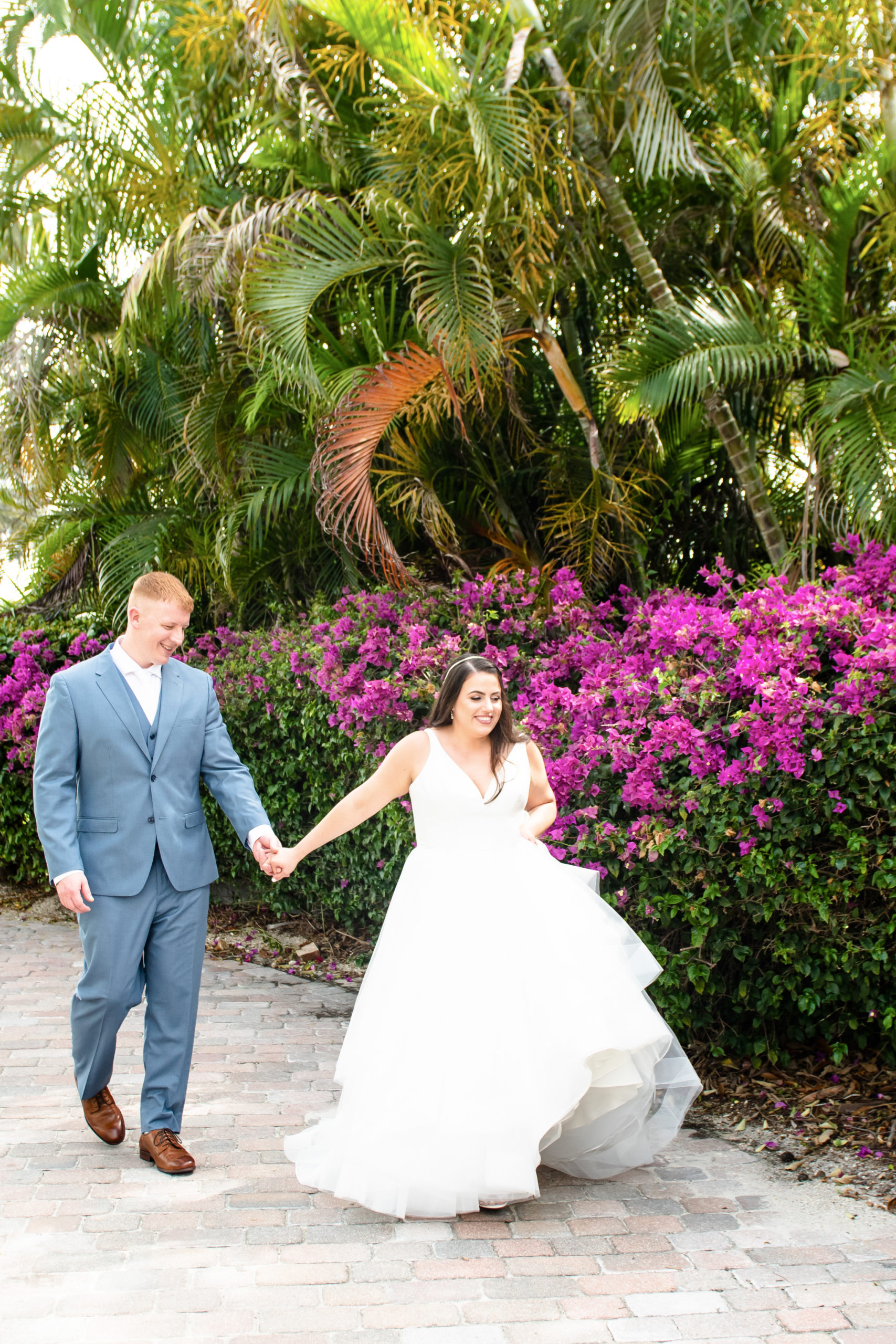 Bride and groom walking by flowers