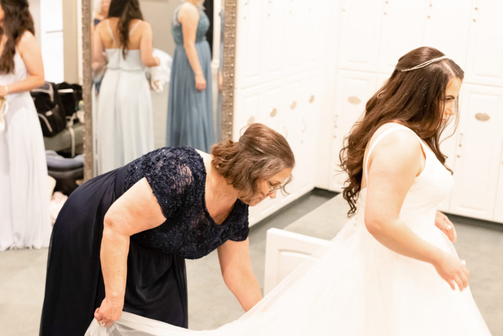 Mother of the bride fixing brides gown