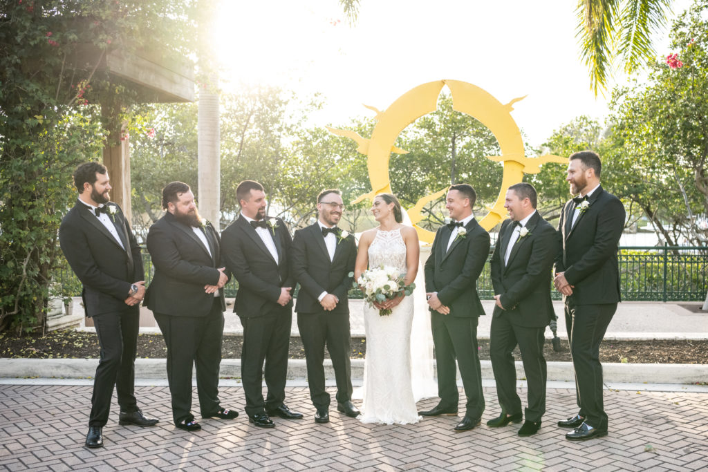 Bride laughing with groomsmen after wedding ceremony 