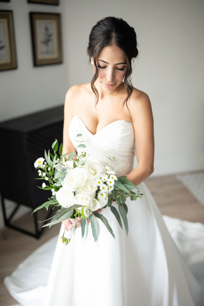 Bride holding bridal bouquet in Pronovias wedding gown 