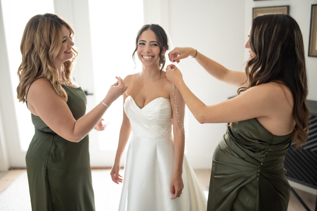 Bridesmaids helping bride with veil on wedding day 