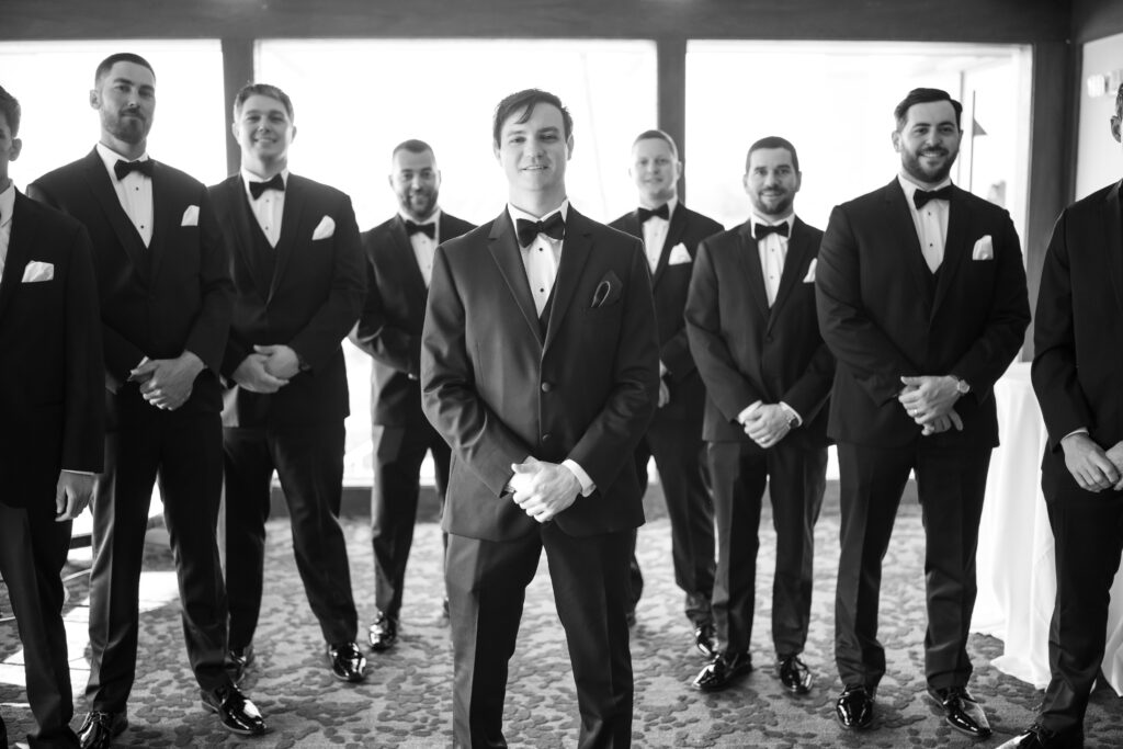 Groom posing with groomsmen in Men's Wearhouse Tuxedos 