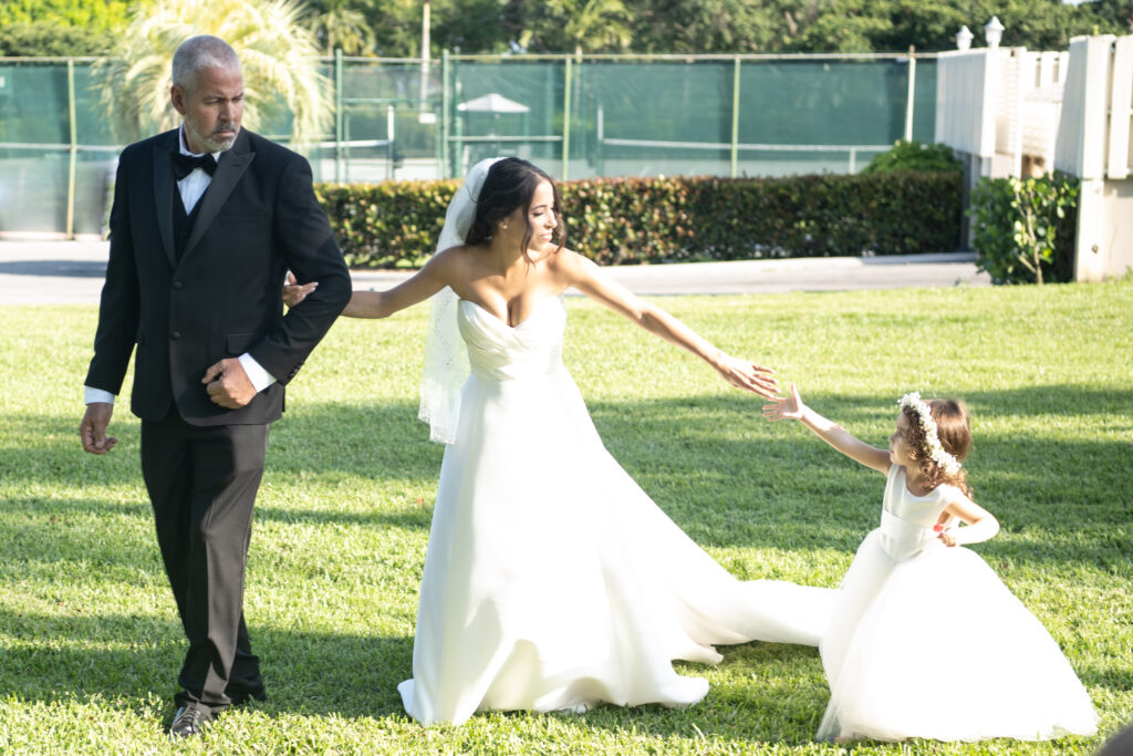 Flower girl reaching for mother while walking down isle on wedding day 